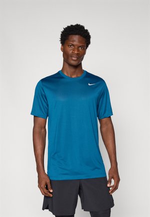 Teal athletic t-shirt with short sleeves, round neckline, and a small white Nike logo on the left chest. Smooth, lightweight fabric.