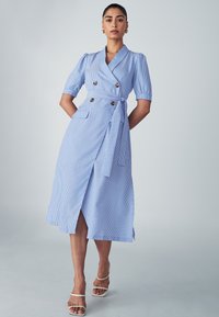 Robe midi rayée bleu clair avec un design à double boutonnage, des manches bouffantes courtes, une taille ceinturée et deux poches avant.