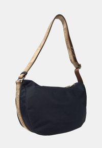 Borsa a spalla nera a forma di mezzaluna con tracolla regolabile stampata con una mappa color marrone e zip dorata sulla parte superiore, su sfondo bianco.