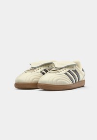 Crèmekleurige sneakers met donkergrijze strepen, bovenwerk van gestructureerd leer, gevoerde tong en bruine rubberen zool. Klassiek ontwerp met gestikte details.
