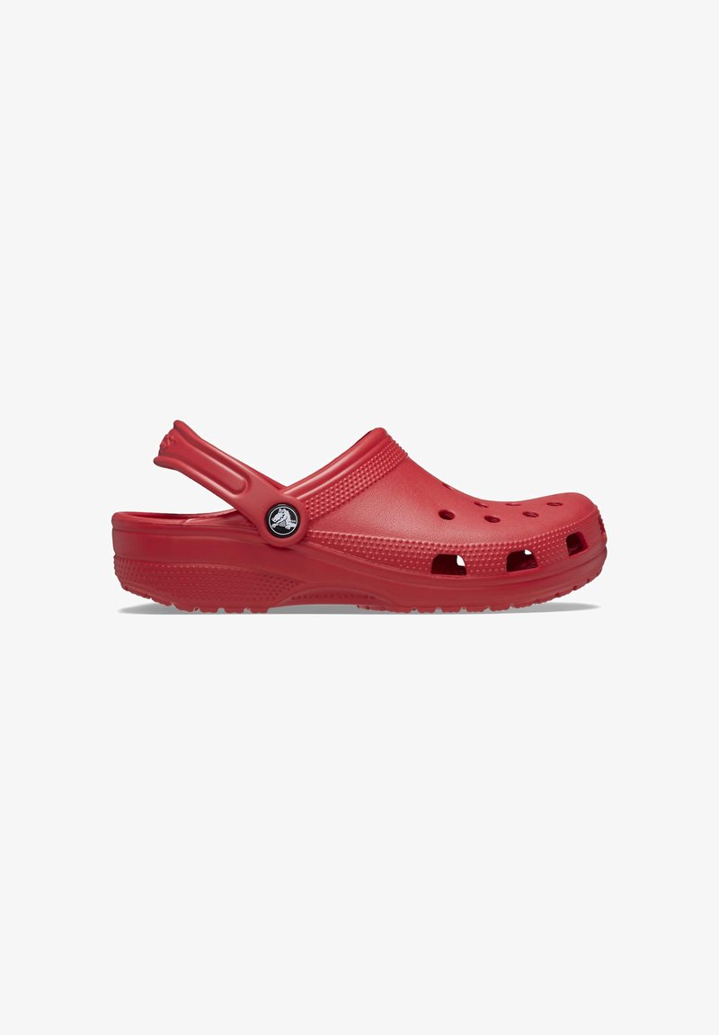 Sabot rouge à enfiler avec des trous de ventilation, une semelle texturée et une bride de talon réglable avec un petit logo circulaire sur fond blanc.