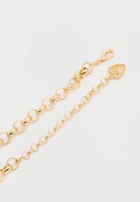 Kaks kuldset ketist käevõru erineva lingi suurusega ja liigendiga, üks lõppeb tekstuurse lehekujulise ripatsiga.