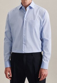 Ljusblå knapp-up skjorta med en bröstficka, krage och långa ärmar; tillverkad av ett mjukt tyg med regular fit.