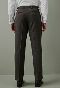 Grå ternede bukser med en slim fit, der har et tekstureret stof, to baglommer med maroon accenter og en glat talje.