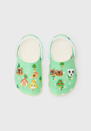 Grønne slip-on tresko med justerbare hvite remmer, dekorert med ansikter til Animal Crossing-karakterer, trær og ikoner på en lys bakgrunn.