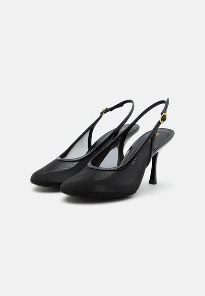 Escarpins slingback noirs à talons hauts avec bouts pointus et brides à boucle dorée, présentés sur fond blanc.