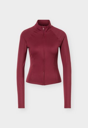 Veste bordeaux ajustée à manches longues avec col montant et fermeture éclair sur le devant, présentée sur un fond clair uni.