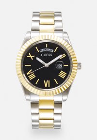Herrklocka med svart urtavla, guldfärgade romerska siffror, armbandsband i silver och guld av rostfritt stål, datumvisning samt fluted guldbeläggning.