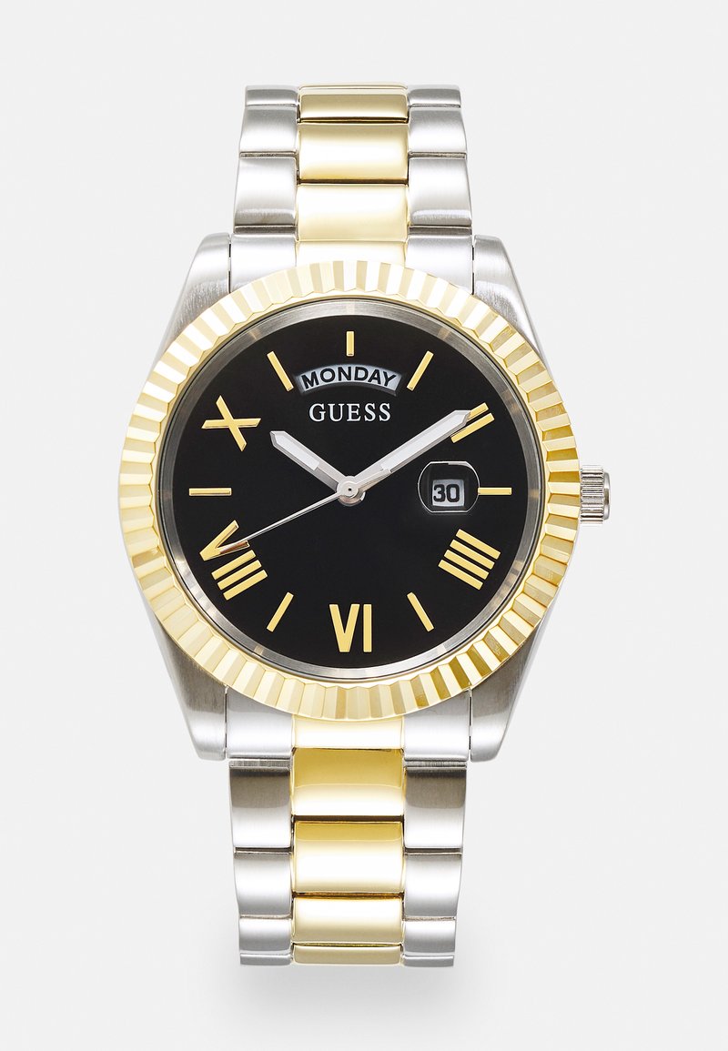Herrklocka med svart urtavla, guldfärgade romerska siffror, armbandsband i silver och guld av rostfritt stål, datumvisning samt fluted guldbeläggning.