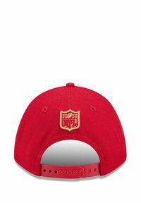 Roter Hut mit einem verstellbaren Kunststoffriemen und einem gestickten NFL-Logo in Gold auf der Rückseite. Hergestellt aus einem Stoff mit glatter Textur.