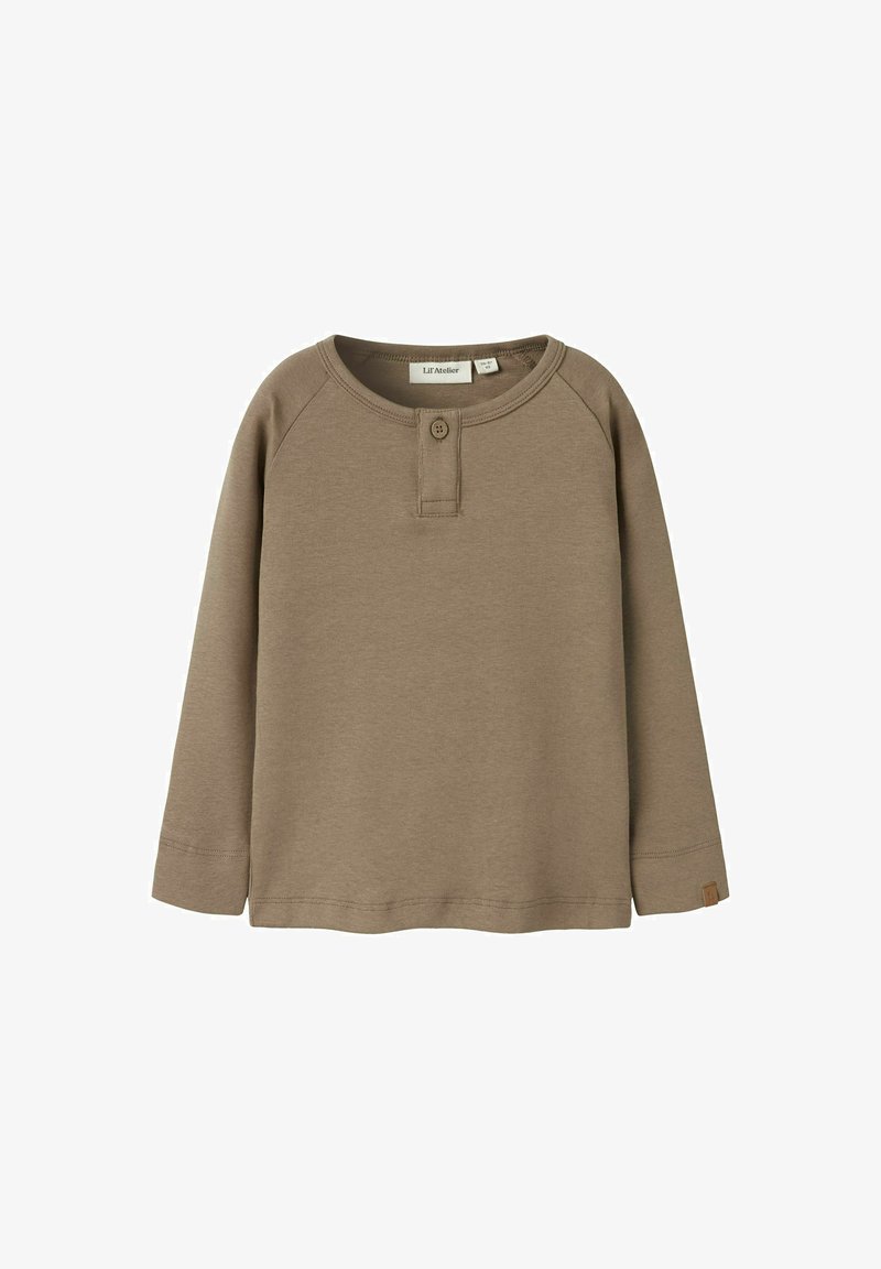 Ilgas rankoves, rudas medvilninis marškinys su apvalia apykakle, su sagų raukšle ir maža logotipo etikete ant apatinio krašto. Lygus paviršius.