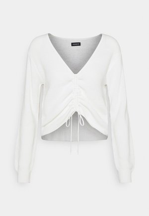 Witte cropped sweater met een V-hals, lange pofmouwen, geplooide voorkant en verstelbare koord aan de zoom. Zachte, gestructureerde stof.