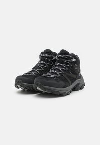 Scarpe da trekking nere con superficie testurizzata, tallone rinforzato e suola in gomma con profili profondi; lacci e occhielli con motivo argentato.