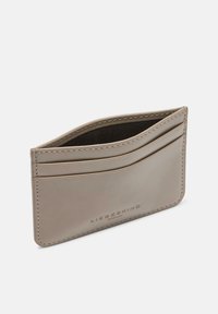 Skórzany etui na karty w beżowym kolorze o gładkiej fakturze, wyposażone w wiele przegródek na karty oraz subtelne przeszycia. Zaprojektowane dla kompaktowej funkcjonalności.