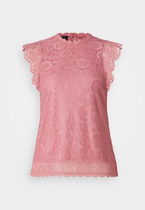 Top en dentelle rose avec un col haut, des manches à bordure festonnée, des motifs floraux complexes et une texture semi-transparente avec un ourlet festonné.