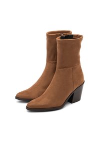 Stivaletti in suede marrone con punta affusolata, design slip-on e tacco spesso, caratterizzati da dettagli di cucitura e una superficie liscia.