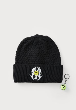 Schwarze Strickmütze mit einem gerippten Saum, der ein weißes Flammenmuster und ein gelbes Smiley-Gesicht zeigt. Enthält einen grünen Smiley-Schlüsselanhänger.