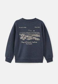 Felpa blu navy con un design grafico di una scena di spiaggia con testo. Composizione in cotone misto, maniche lunghe, polsini e orlo a costine.