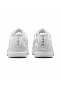 Weiße Sportschuhe mit einem strukturierten Mesh-Obermaterial, dicken Sohlen und dezentem Branding am Fersenbereich in Schwarz.