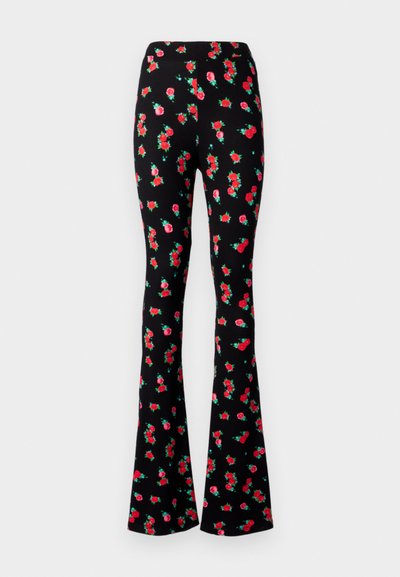 Pantalons évasés noirs avec un motif floral de roses rouges et de feuilles vertes, fabriqués à partir d'un tissu extensible, avec une taille haute.