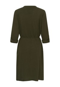 Olivno zelena obleka z dolgimi zavihanimi rokavi, ovratnikom, pasom z zavezovanjem na pasu in sproščenim krojem. Mehka tekstura in enobarvna tkanina.