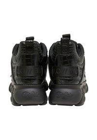 Par de zapatillas Buffalo negras con plataforma, vistas desde atrás, con material texturizado y lengüetas y medias suelas con la marca.