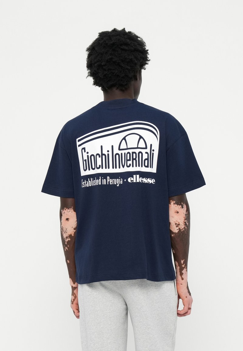 Mørkeblå bomulds t-shirt med et hvidt grafisk print på ryggen, der står "Giochi Invernali" og "Established in Perugia · ellesse."