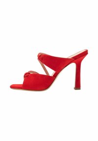 Sandale à talons hauts en suède rouge avec un bout ouvert et des brides croisées. Caractéristiques des détails en nœud et un talon fin et droit. Semelle lisse.