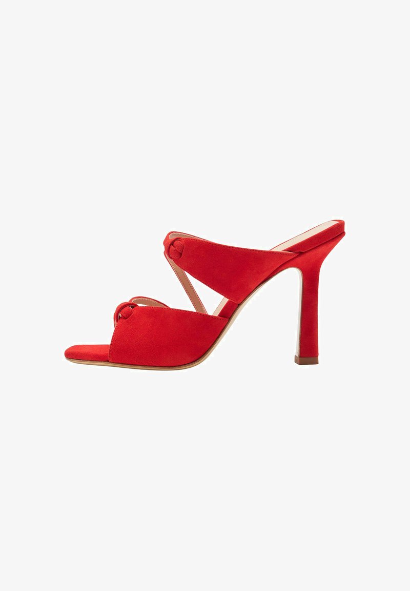 Sandale à talons hauts en suède rouge avec un bout ouvert et des brides croisées. Caractéristiques des détails en nœud et un talon fin et droit. Semelle lisse.