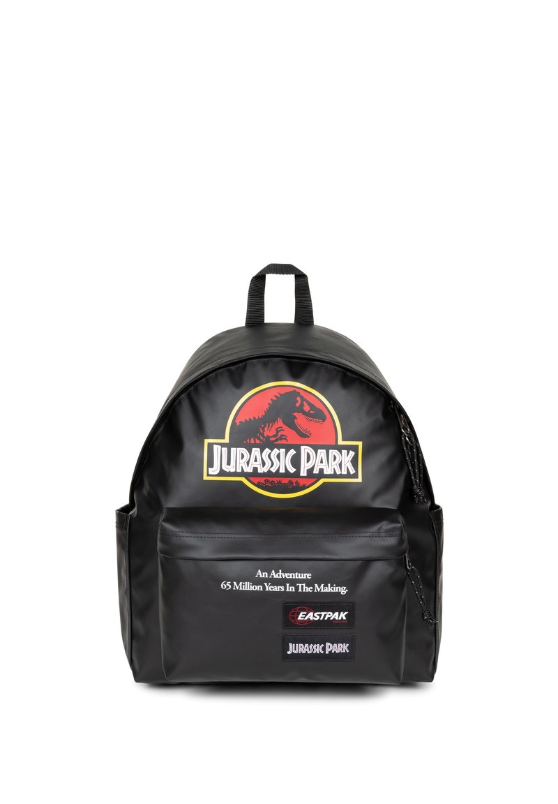 Mochila negra con forma redondeada, un gran logo de Jurassic Park y un bolsillo con cremallera en la parte frontal que incluye detalles en texto. Fabricada con material duradero.