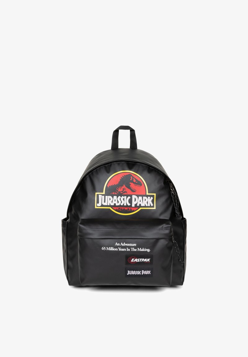 Mochila negra con forma redondeada, un gran logo de Jurassic Park y un bolsillo con cremallera en la parte frontal que incluye detalles en texto. Fabricada con material duradero.