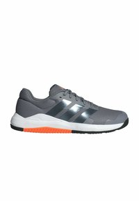 Zapatilla deportiva gris con parte superior de malla, tres franjas negras y reflectantes, acentos naranjas en la suela y un acabado texturizado.