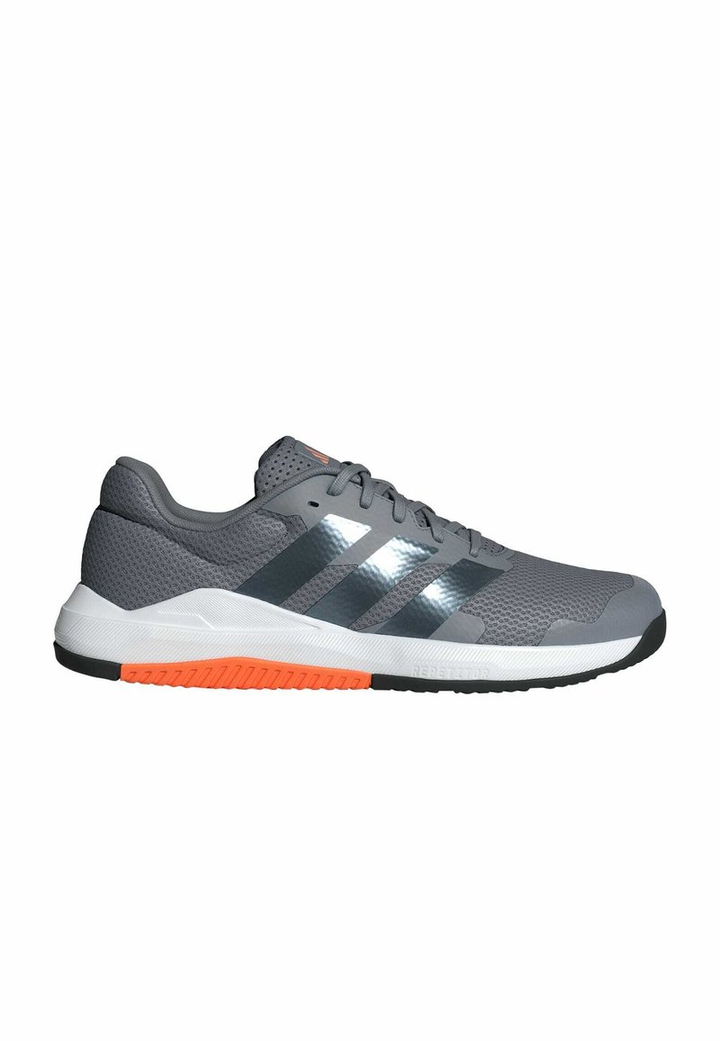 Zapatilla deportiva gris con parte superior de malla, tres franjas negras y reflectantes, acentos naranjas en la suela y un acabado texturizado.