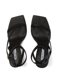 Sorte flade sandaler med tynde stropper, firkantet tådesign og en glat lædertekstur. Justerbar ankelrem med spænde.