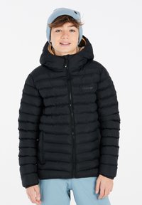 Chaqueta negra acolchada con capucha, con cierre de cremallera y puños elásticos. Usada sobre pantalones de un azul claro, con un gorro de punto azul claro.