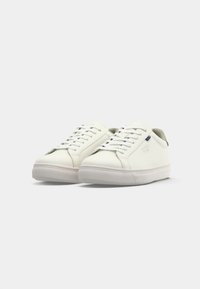 Pair of clean white low-top sneakers with laces and minimal design, placed side by side on a plain light background.