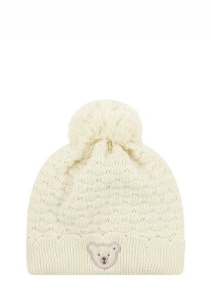 Knitted cream beanie with a textured pattern, rounded top, and a fluffy pom-pom. Features a bear face patch on the front.