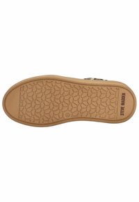 Semelle en caoutchouc brun avec un motif en nid d'abeille et le marquage "Steve Madden", dotée d'un bord texturé pour l'adhérence. Design plat.