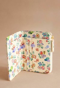 Portafoglio con motivo floreale realizzato in materiale crema texturizzato. Dotato di più scomparti per carte e chiusura a scatto. Gli accenti includono un bottone dorato.