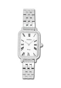 Montre rectangulaire argentée avec des chiffres romains, un cadran blanc et une lunette ornée de cristal. Équipée d'un bracelet en métal à maillons.