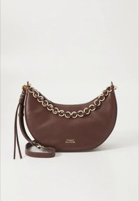 Brown leather handbag with a curved shape, gold chain accent, and a detachable strap. Features a tassel detail on the side.