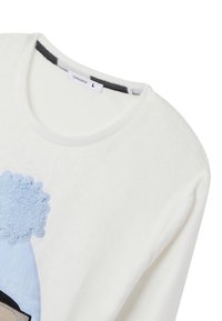 Felpa bianca in pile con collo rotondo, caratterizzata da un design testurizzato blu chiaro che ricorda onde o riccioli, e un accento nero vicino all'orlo.