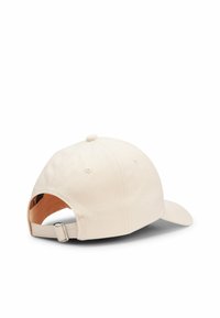 Light beige baseball cap with a curved brim, adjustable back strap, and small top button. Made of cotton with ventilation holes.
