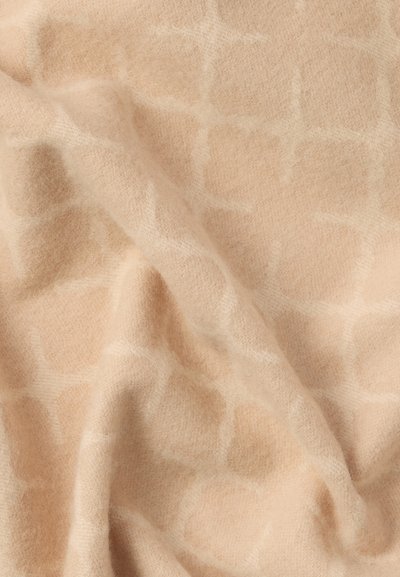 Tkanina w kolorze brzoskwiniowym o miękkiej, fakturowanej powierzchni z subtelnym geometrycznym wzorem, prezentująca przytulną i zachęcającą cechę.