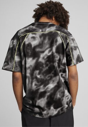 Czarny i szary t-shirt w stylu tie-dye z krótkimi rękawami, okrągłym dekoltem, odblaskowymi żółtymi przeszyciami na ramionach oraz luźnym krojem.