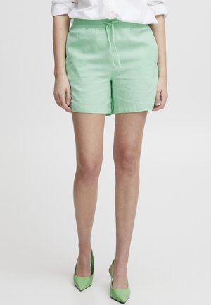 Pantaloni corti in lino verde menta con vita elasticizzata e lacci regolabili. Tessuto morbido, vestibilità sagomata e design fino al ginocchio.