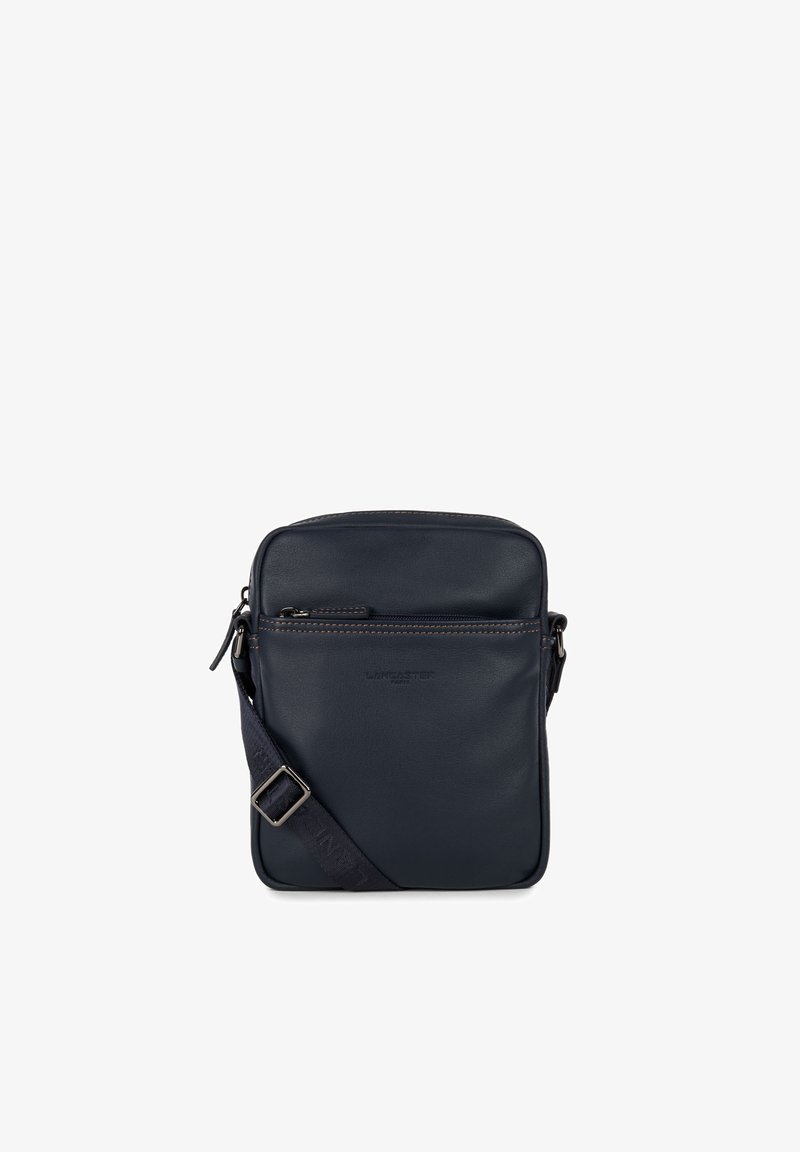 Marineblaues Leder-Crossbody-Tasche mit einer Reißverschlusstasche an der Vorderseite, verstellbarem Tragegurt und subtiler tonaler Naht. Glatte Textur mit rechteckiger Form.