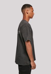 Gray oversized t-shirt with short sleeves, a crew neck, and distressed texture; features "MADE UP" printed on the back.