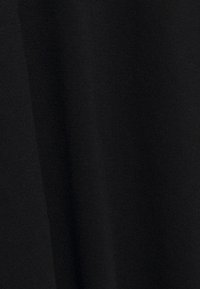 Svart tyg med en slät textur, som visar en närbild av vävningen. Inga distinkta mönster eller detaljer synliga.