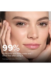 Close-up van een gezicht met een gladde, heldere huid, die een lichte glans op de lippen toont en een natuurlijke make-up heeft. Handen die voorzichtig het gezicht vasthouden.